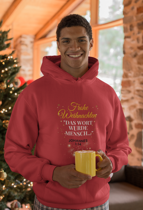 Man wearing a red hoodie with Christmas text, holding a yellow mug in a festive setting.