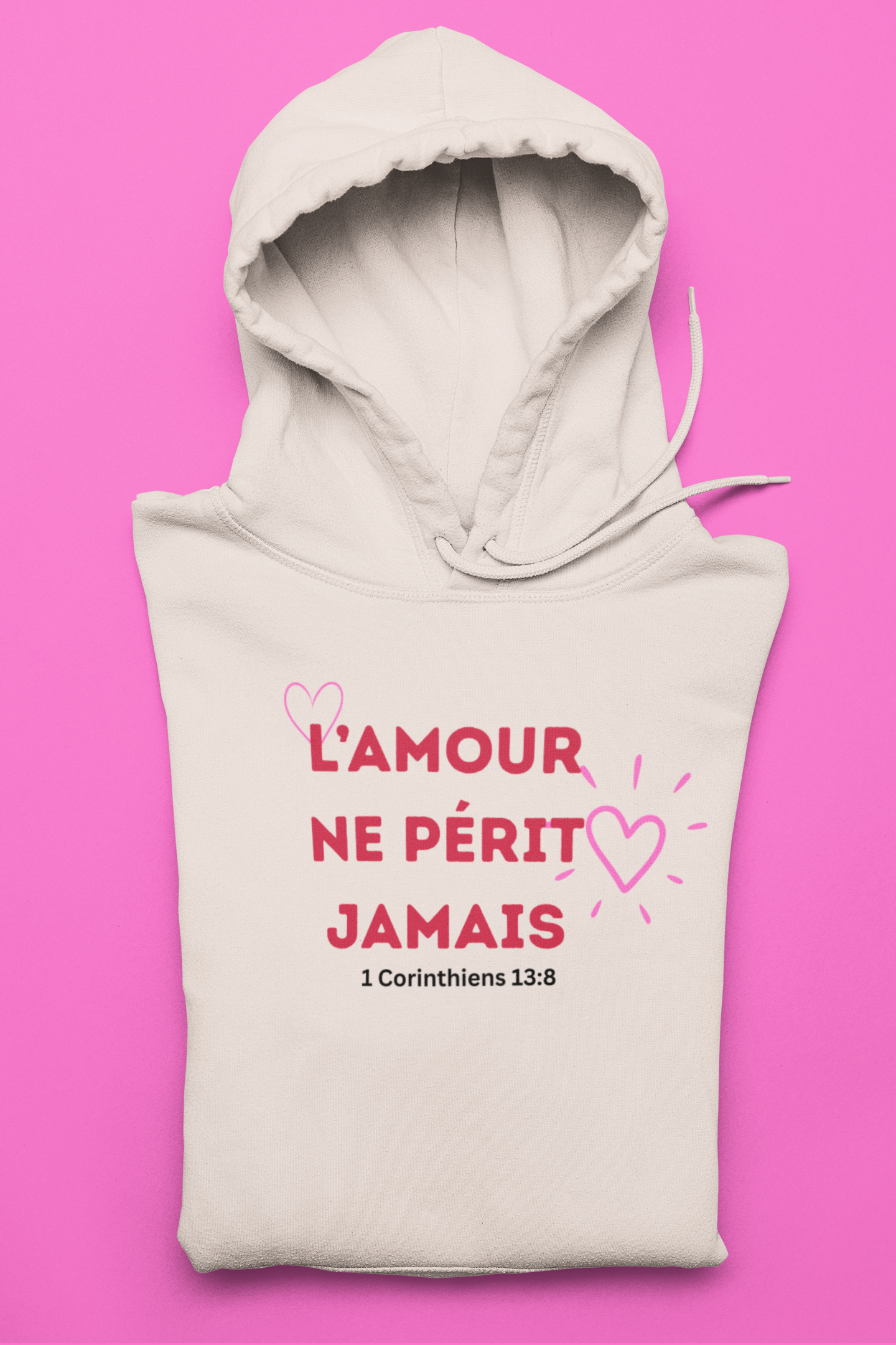Beige hoodie with pink text and hearts on a pink background