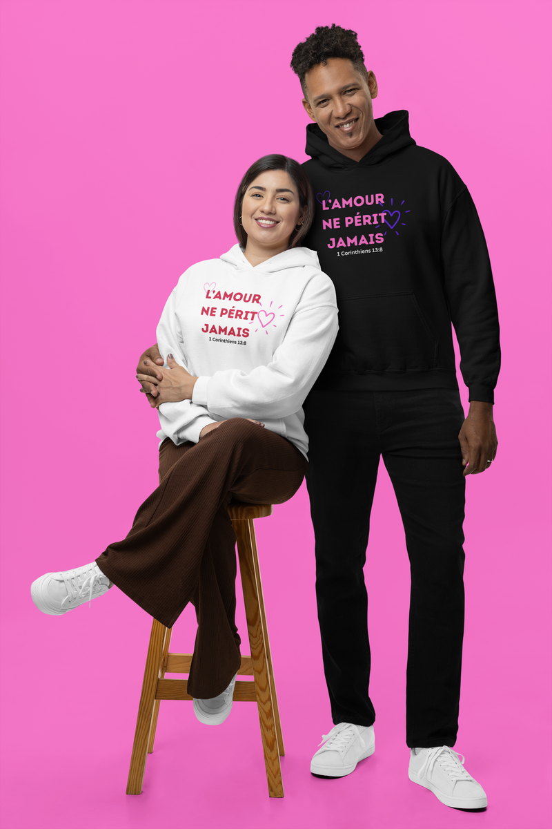 Two people wearing hoodies with French text on a pink background