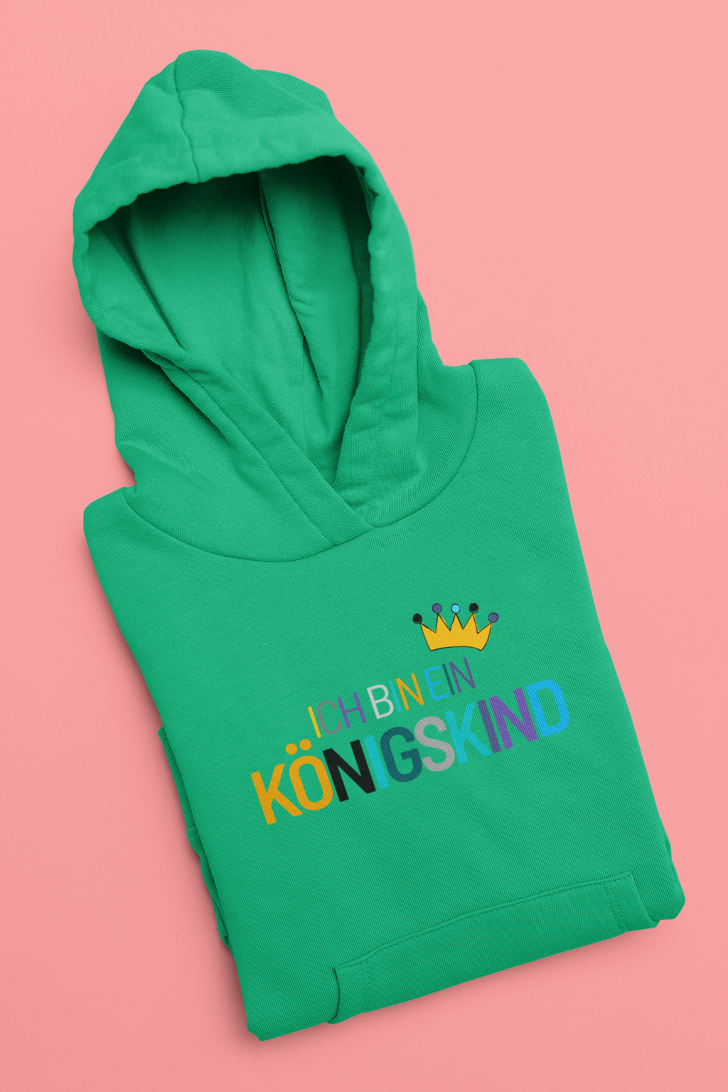 Green hoodie with colorful text and a crown on a pink background
