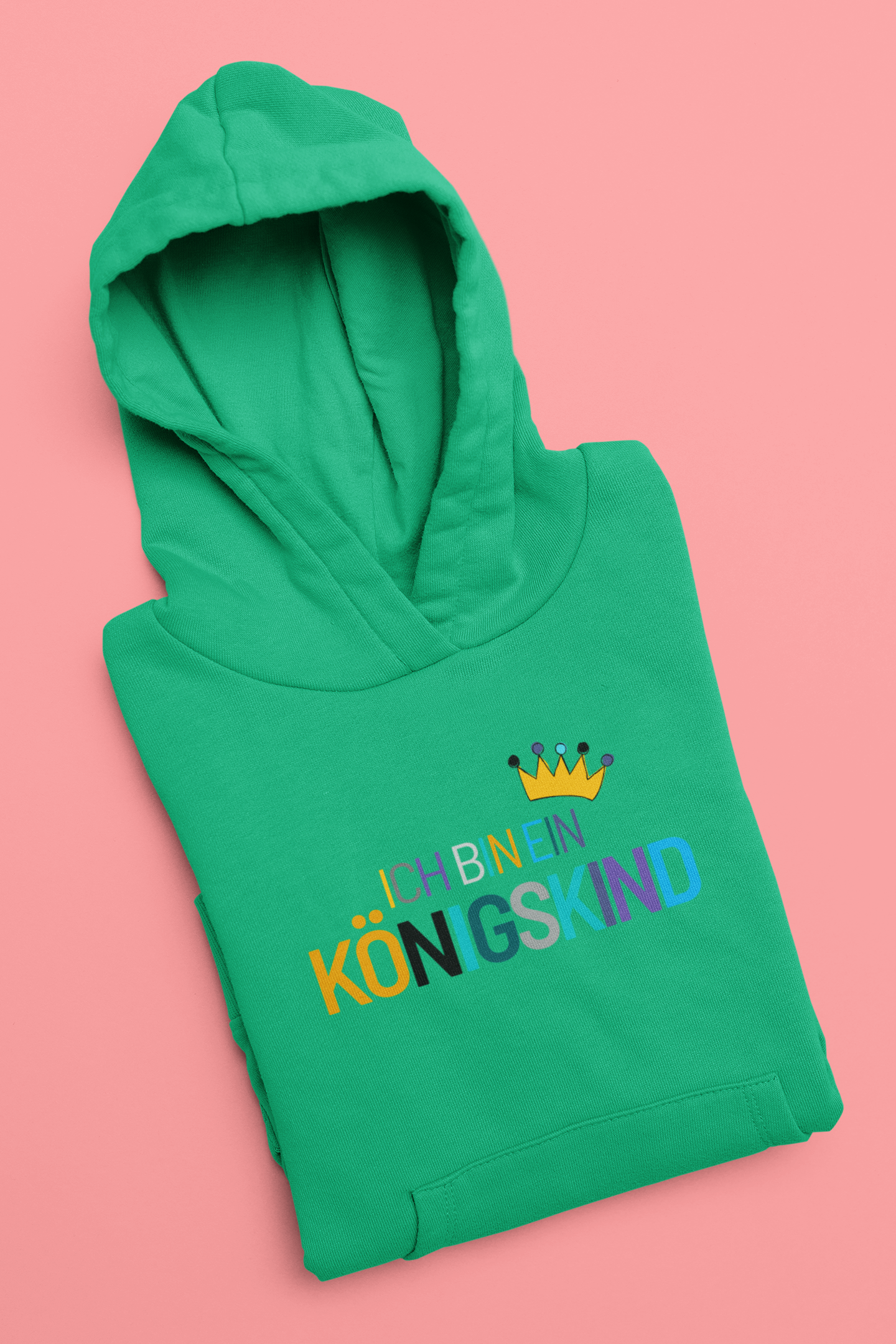 Green hoodie with colorful text and a crown on a pink background