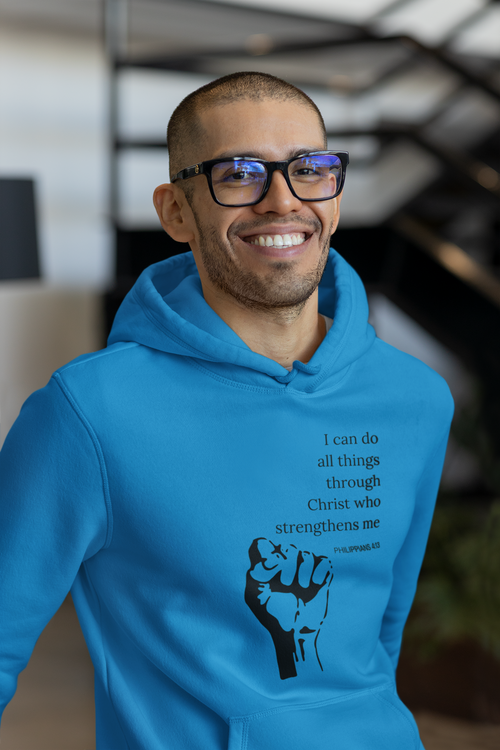 Man wearing a blue hoodie with a motivational quote and fist graphic, standing indoors.