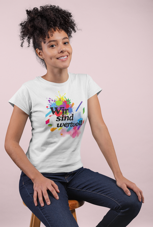 Person wearing a white t-shirt with colorful design and text on a light pink background