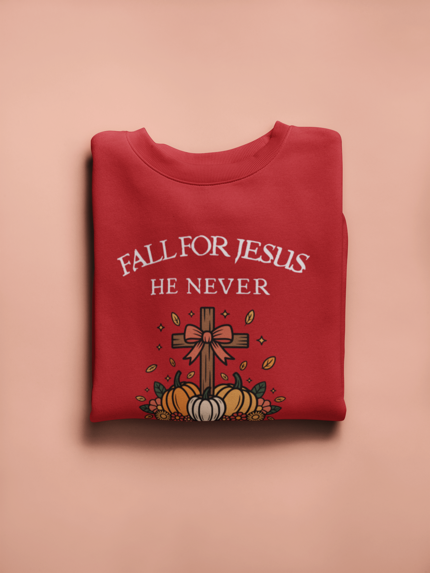 Red sweatshirt with 'Fall for Jesus He Never' text and pumpkins on a pink background