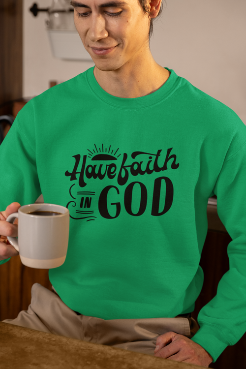 Person wearing a green sweatshirt with 'Have faith in God' text, holding a mug.
