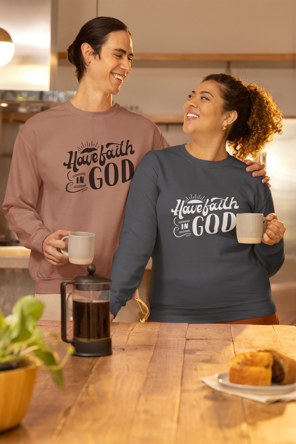 Two people wearing sweatshirts with 'Hate faith in God' text, standing in a kitchen.