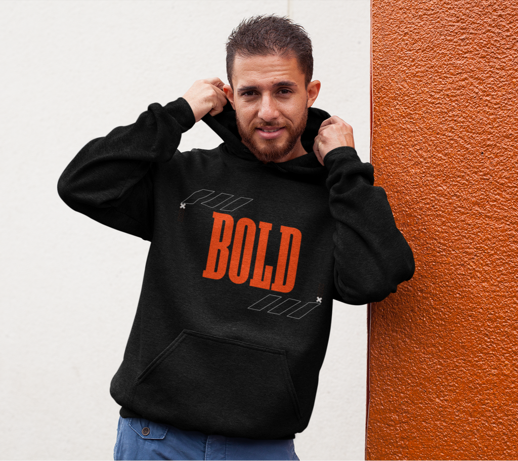 Man wearing a black hoodie with 'BOLD' printed in orange against a white and orange wall.