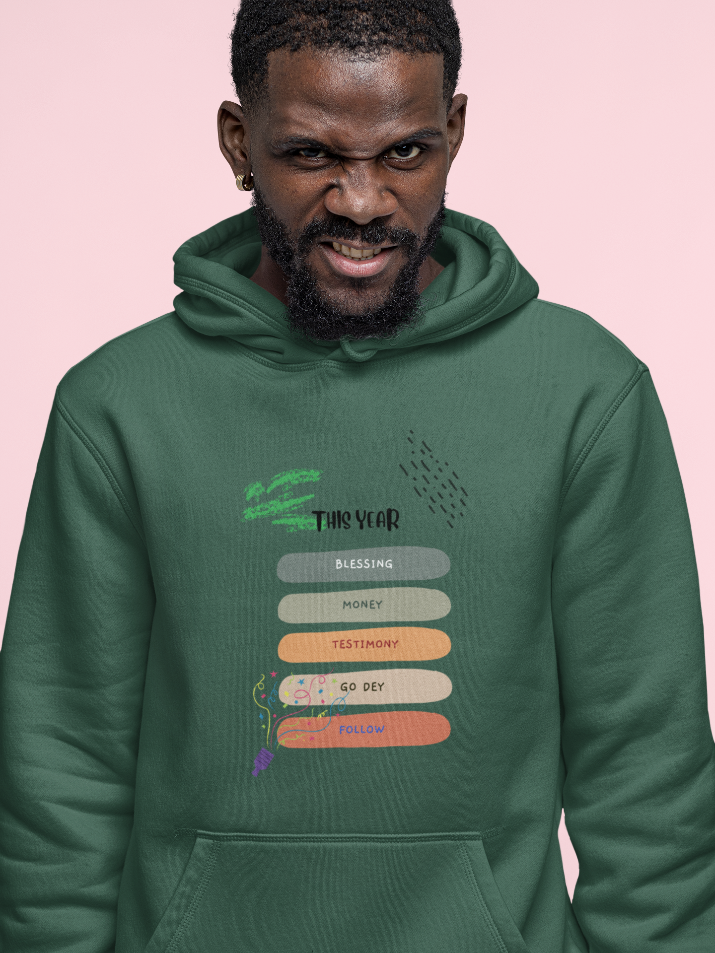 Man wearing a green hoodie with text design on a pink background
