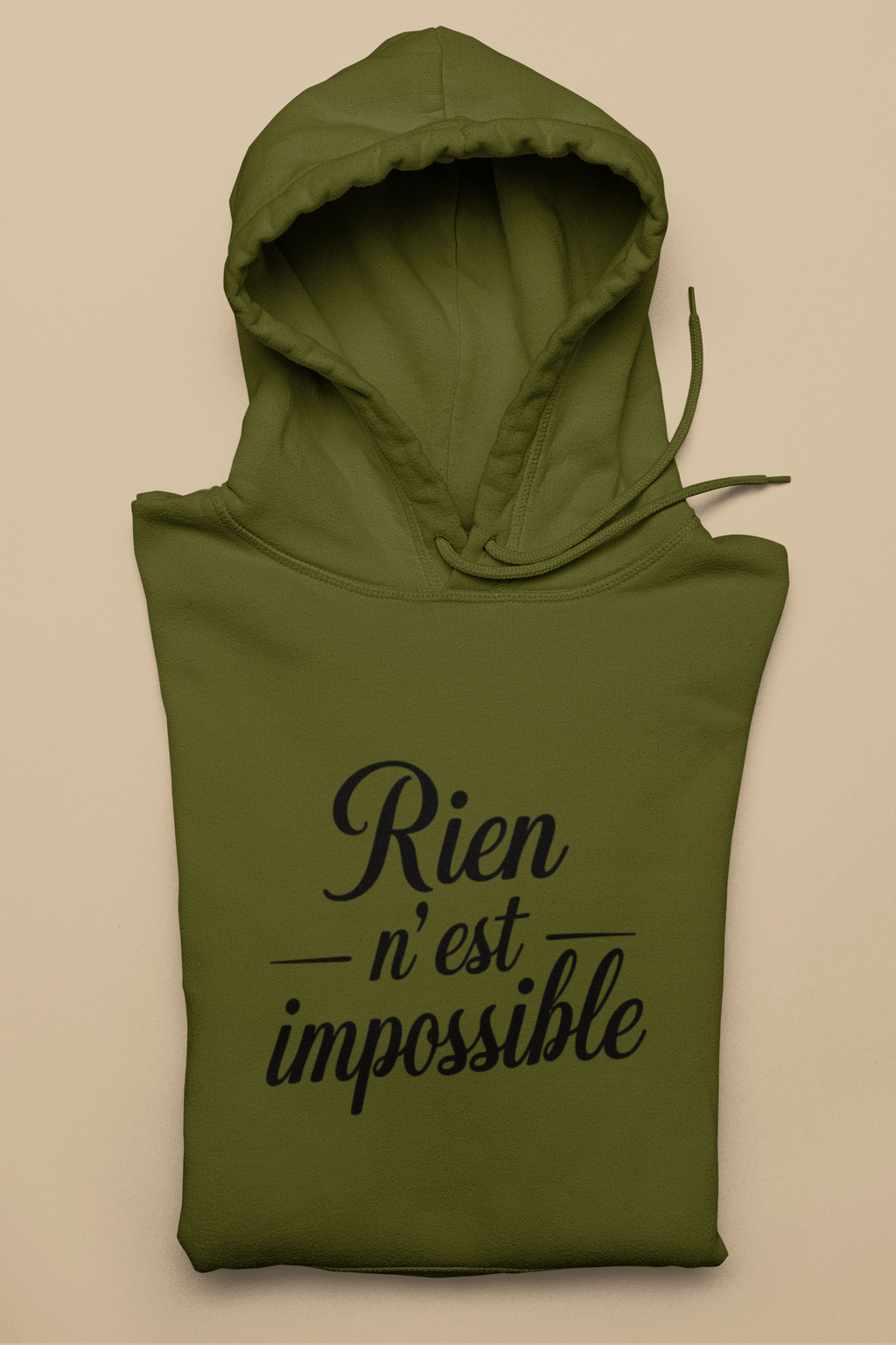 Green hoodie with 'Rien n'est impossible' text on a beige background