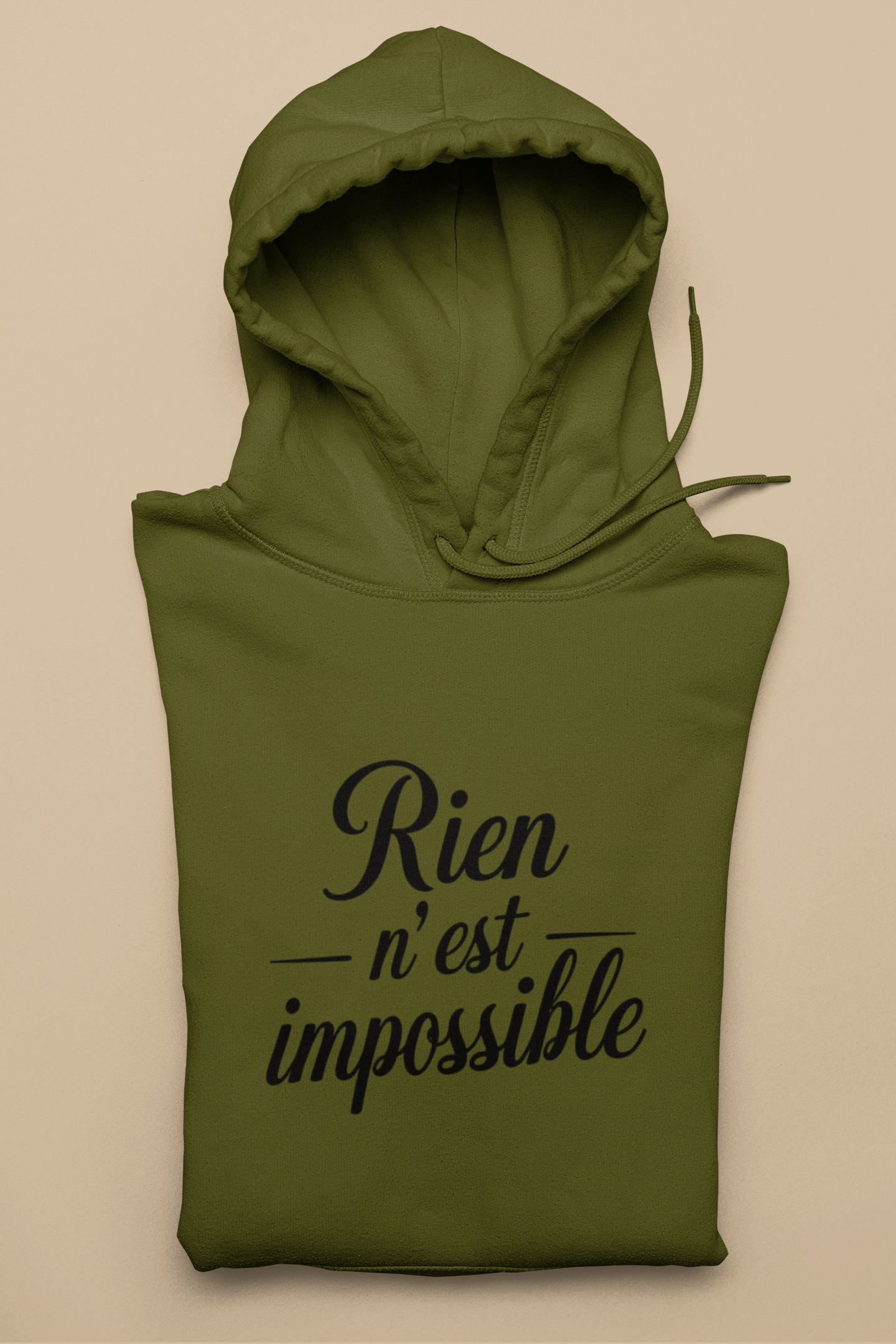 Green hoodie with 'Rien n'est impossible' text on a beige background