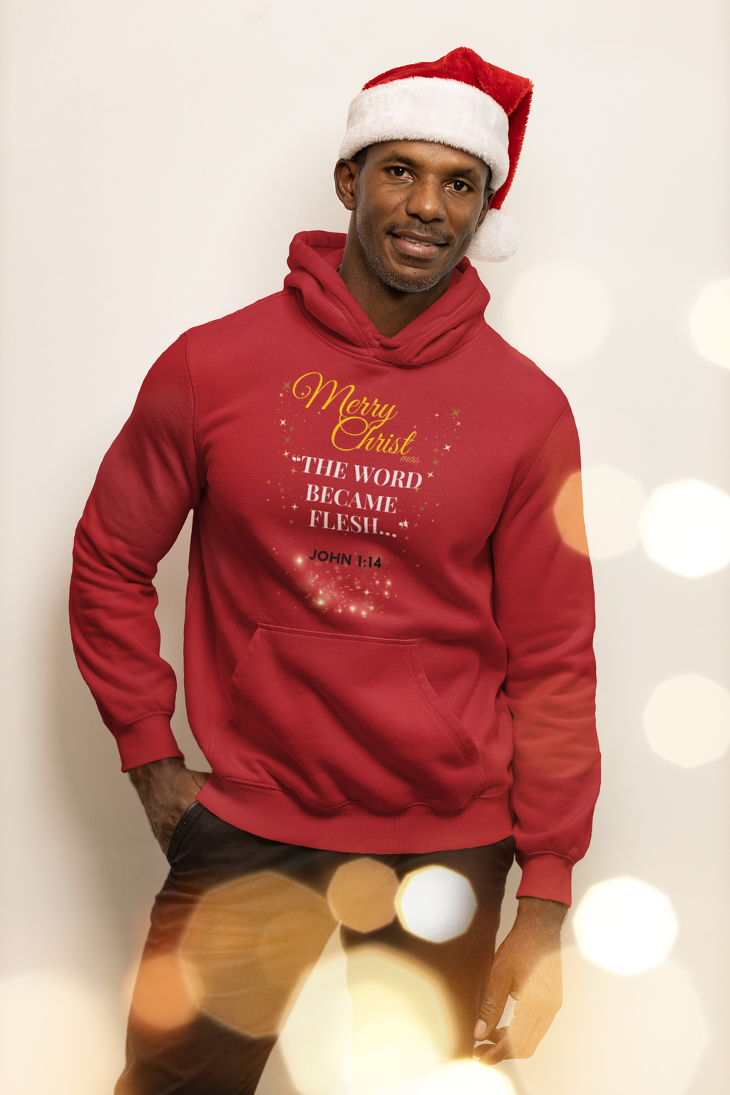 Person wearing a red hoodie with Christmas text and a Santa hat against a bokeh light background