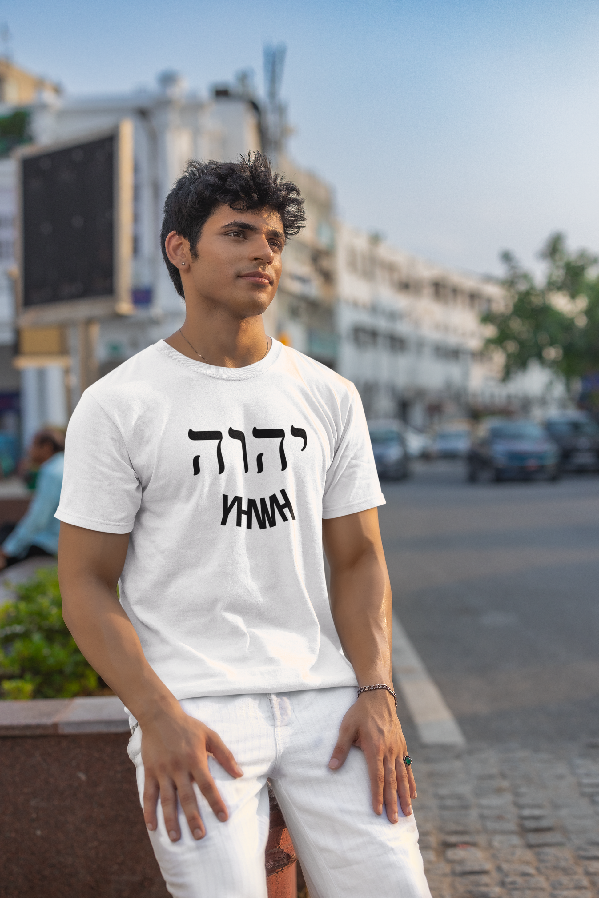 Man wearing a white t-shirt with text on a street background