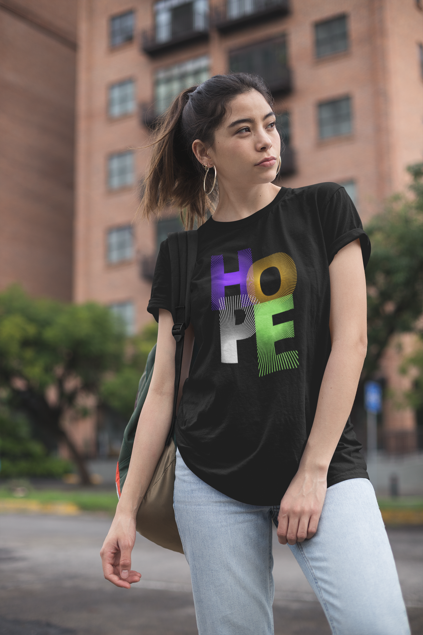 Woman wearing a black t-shirt with colorful 'HOPE' text in an urban setting
